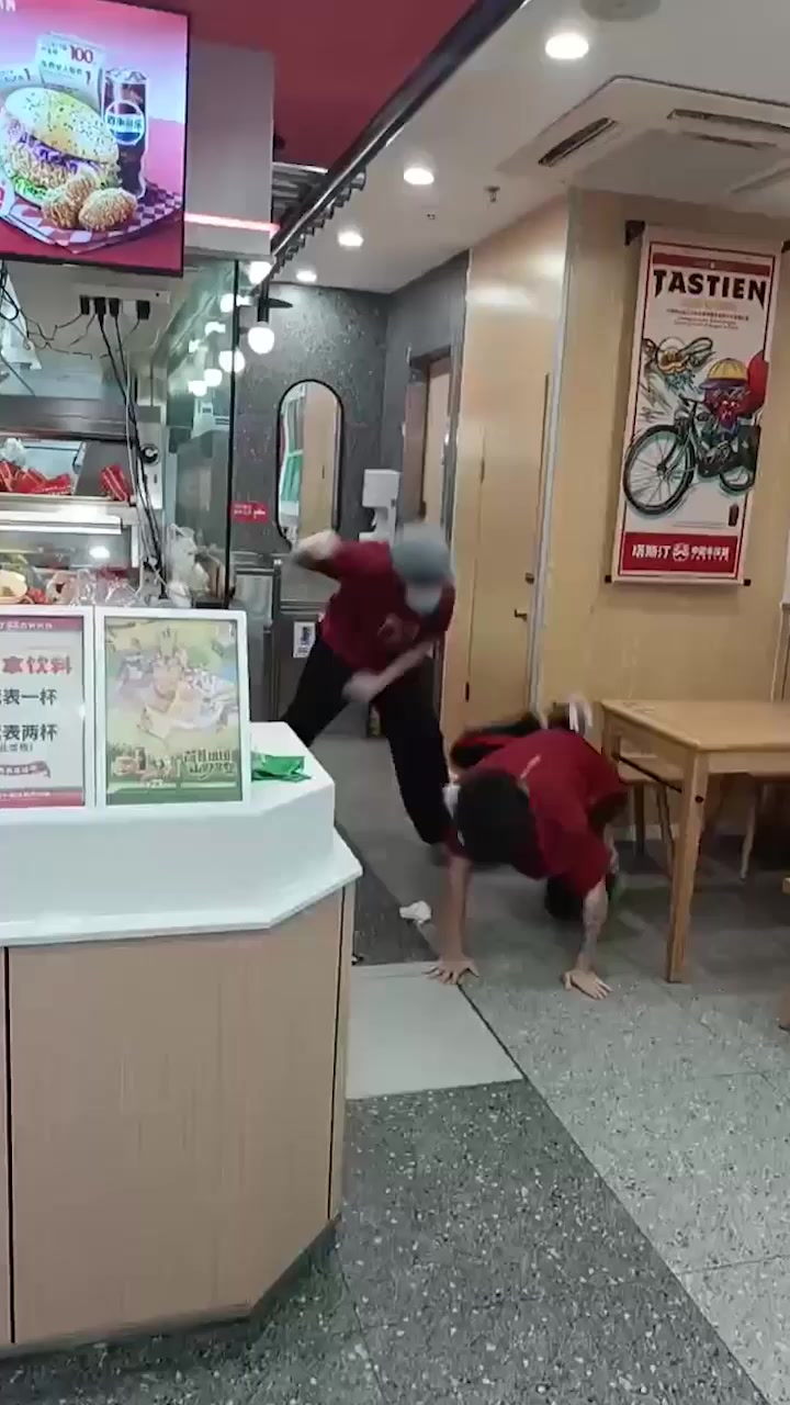塔斯汀店内员工大乱斗 俩小伙互殴爆头 阿姨若无旁人淡定做汉堡 堪称敬业典范！